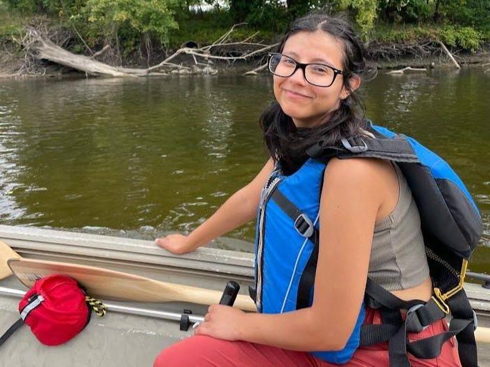 Paris Velasquez conducts fieldwork on a lake.